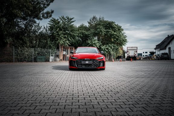 Roter Audi RS5 B10 von vorne mit schwarzem Kühlergrill und abgesenkter Fahrzeughöhe.