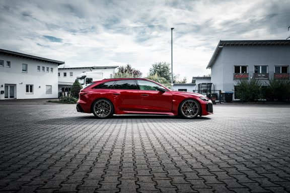 Roter Audi RS5 B10 im Seitenprofil vor der Werkstatt mit reduziertem Abstand zwischen Reifen und Radhaus.