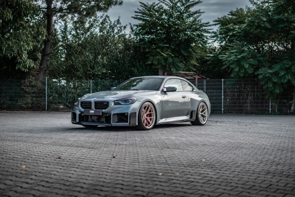 BMW M2 G87 schräg von vorn mit KW V3 Gewindefahrwerk und Edelweiss-Rädern in Champagne.