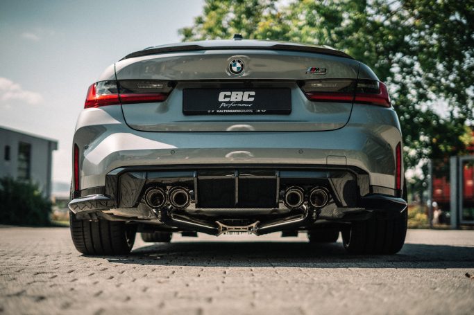 Heckansicht des BMW M3 G80 mit vier schwarzen Capristo-Endrohren, Diffusor und CBC-Performance-Kennzeichen.