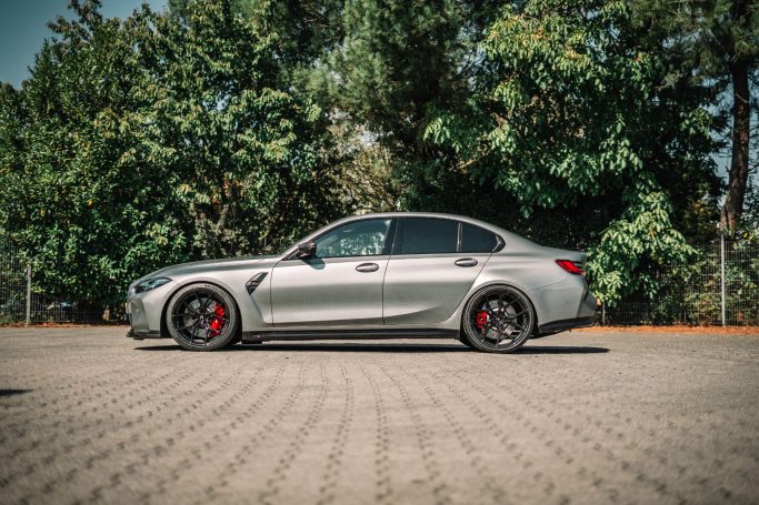 BMW M3 G80 im Seitenprofil mit tiefergelegter Karosserie, schwarzen Yido-Rädern und roten Bremssätteln.