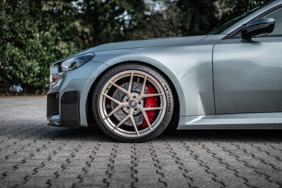 Edelweiss-Vorderrad in Champagne am BMW M2 G87 mit rotem Bremssattel und Michelin-Reifen.
