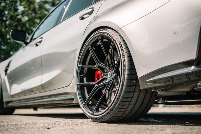 Yido YP-RS1 Hinterrad in Gloss Black am BMW M3 G80 mit rotem Bremssattel und breitem Michelin-Reifen.