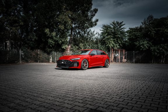 Roter Audi RS5 B10 schräg von vorne mit H&R Gewindefedern und originalen 21-Zoll-Rädern.