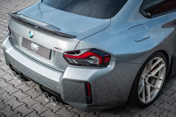 Detail des BMW M2 G87 mit Carbon-Heckspoiler, M2-Emblem und rechter Rückleuchte.