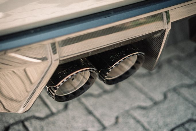 Schräg von oben aufgenommene schwarze Capristo-Doppelendrohre unter dem Heckdiffusor des BMW M3 G80.