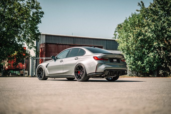 BMW M3 G80 schräg von hinten mit schwarzen Yido-Rädern, Heckspoiler und vier Capristo-Endrohren.